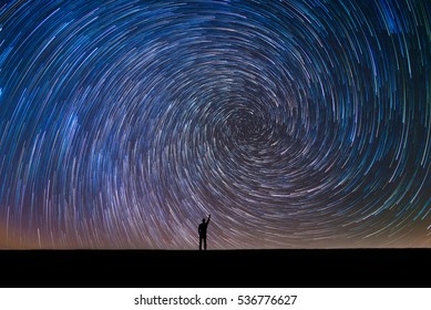 Man Pointing North In A Spiral Star Trail