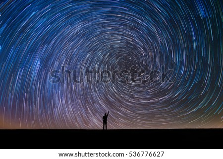 Man Pointing North in a spiral star trail