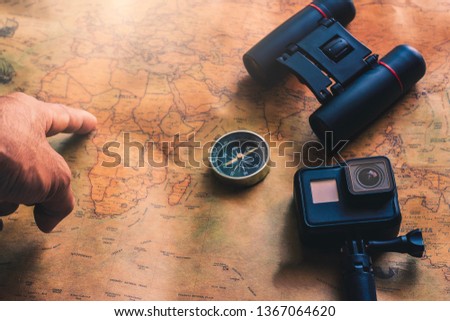 Man pointing Notepad for note with binoculars pencil, compass on paper map for travel adventure discovery image