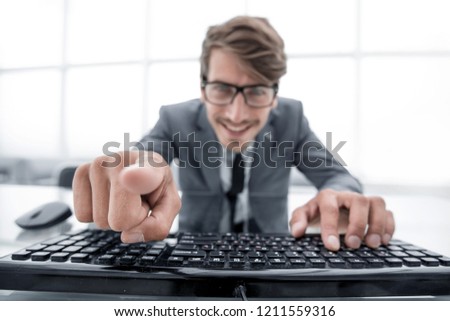 man pointing at something with finger and using computer keyboar
