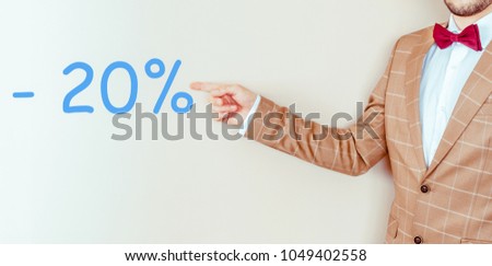 man pointing at twenty percent discount sign