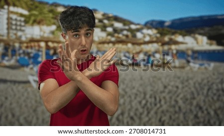 Man points finger at camera in a studio with beach backdrop and sand umbrellas; determination resolve.