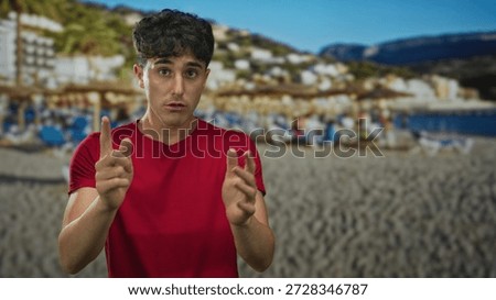 Man points finger at camera in a studio with beach backdrop and sand umbrellas; determination resolve.