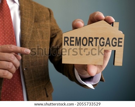 The man points to the remortgage inscription on the house.