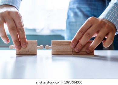The man points to the same two incompatible jigsaw puzzles. The concept of misunderstanding, non-conforming elements, mutually exclusive statements.