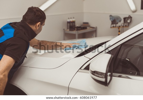 A
man polishes a white machine with a polishing
machine