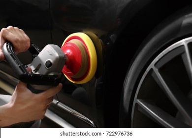 Man Polishing Car With Power Buffer Machine In Repair Shop