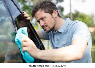 Man Polishing His Car With A Cloth