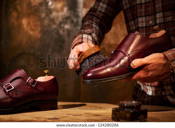 Man polishing leather\
shoes with brush.
