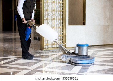 man polishing marble floor in modern office building