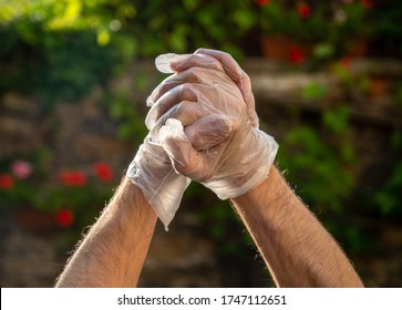 Man In Polyethylene Gloves Outdoors. Male Showing OK Sign