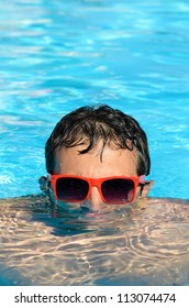 Man In Pool Having Fun On Summer Holidays. Young Man Swimming And Lurking On Vacation. Half Head Above Water Stalking.