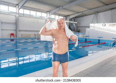 A man in the pool wipes himself with a white towel