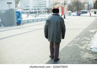 Man in poor clothes. Life of old man in city. Man from behind.