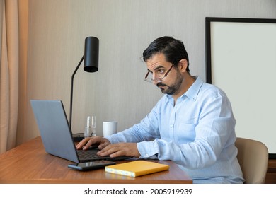 Man With A Poor Eyesight Working In His Laptop, Struggling To See