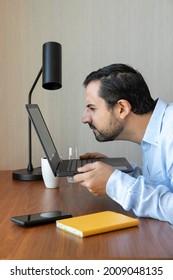 Man With A Poor Eyesight Working In His Laptop, Struggling To See