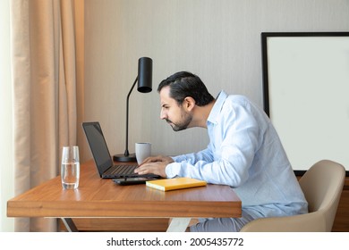 Man With A Poor Eyesight Working Inhis Laptop, Struggling To See