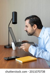 Man With A Poor Eyesight Working Inhis Laptop, Struggling To See