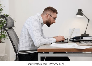 Man with poor posture working in office