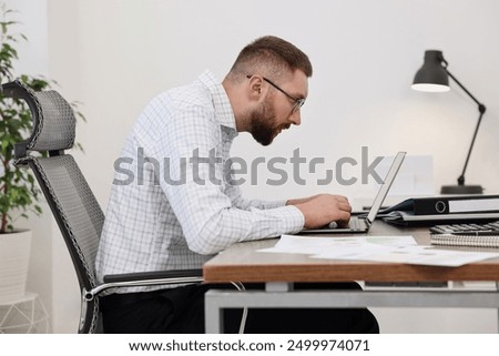 Man with poor posture working in office