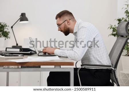 Man with poor posture working in office