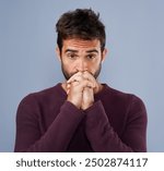 Man, portrait and anxiety prayer in studio, worry and ask God for support or help on blue background. Male person, hands together and nervous worship for assistance, religion and spiritual suspense