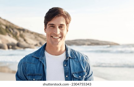 Man, portrait and beach with sunshine and smile in the outdoors for an adventure and happiness. Ocean, sun and male person is happy in the outdoor for day to relax in the summer with nature and air. - Powered by Shutterstock