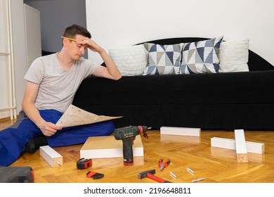 Man Portrait And Do It Yourself Furniture Assembly. Concentrated Young Man Reading The Instructions To Assemble Furniture.