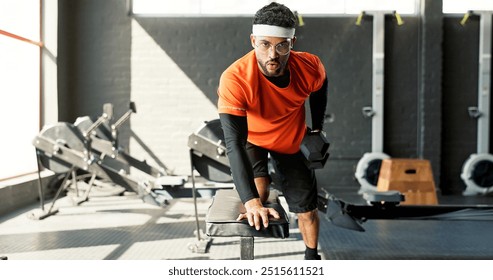 Man, portrait or fitness with dumbbells at gym for weightlifting workout, exercise or training. Young, active or male person lifting weights for muscle, bicep curl or wellness on bench at health club