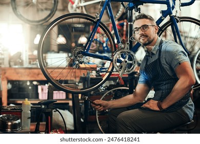 Man, portrait and fixing at work in bicycle repair shop or maintenance garage. Bike, mechanic and service with a professional handyman for startup, small business and mechanical vehicle workshop - Powered by Shutterstock