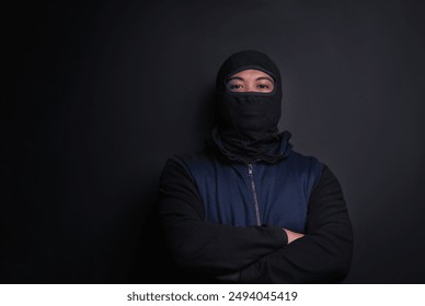 Man, portrait and mask of robber in studio, burglar and criminal or black background for thief. Male person, balaclava and disguise for bad guy on mockup space, danger and gangster for illegal action