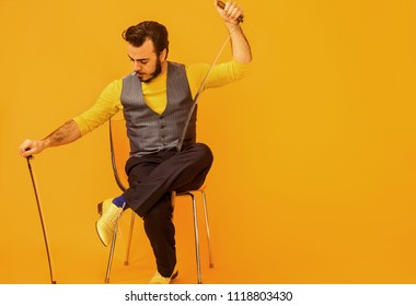 Man Portrait Sitting On Chair While Holding Musical Saw