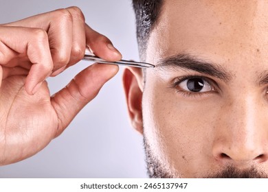 Man, portrait and trim eyebrow on face in studio, selfcare and personal grooming. Model, hygiene and person with tweezers for hair removal for beauty, wellness and treatment in grey background - Powered by Shutterstock