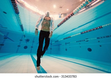 Man Portrait Wearing White Shirt Inside Swimming Pool. Underwater Image.