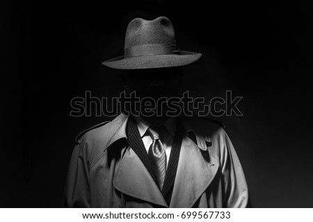 Man posing in the dark with a fedora hat and a trench coat, 1950s noir film style character