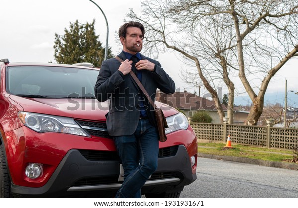 A man posing in front of a\
car