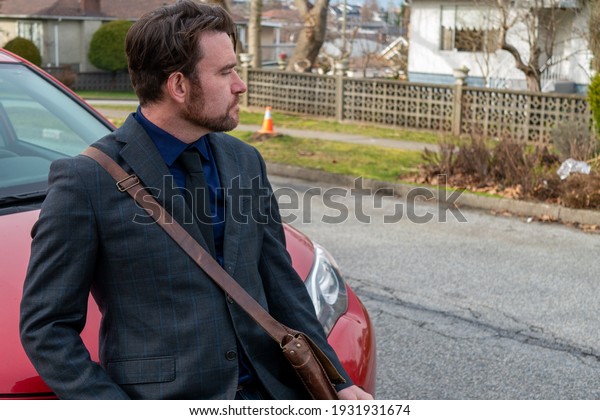 A man posing in front of a
car
