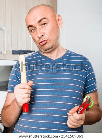 Man posing with hammer in his hands