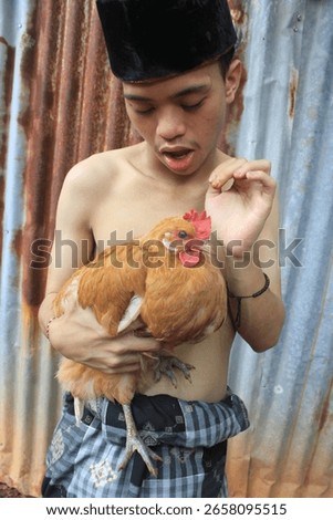 a man is posing hugging a chicken without wearing clothes as if he is closely related to his pet.