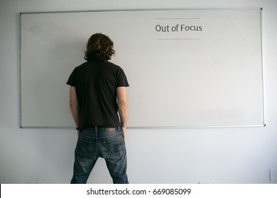 A man posing as a model with a whiteboard in a funny way