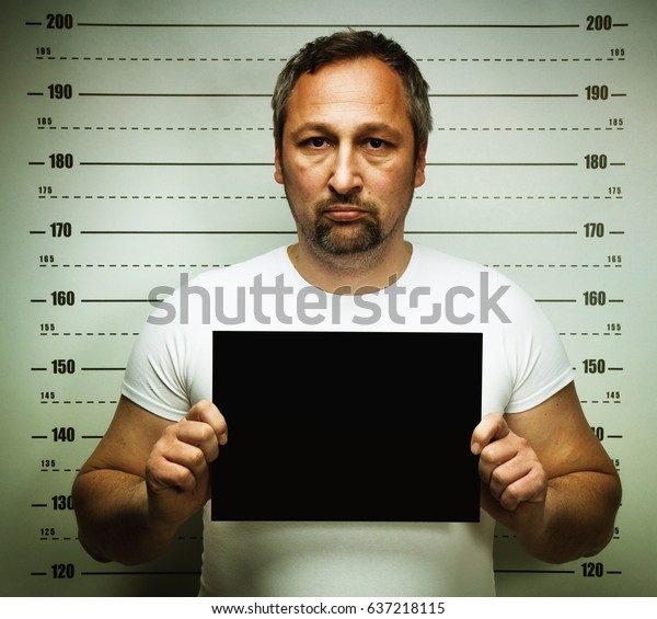 man posing for police\
mugshot