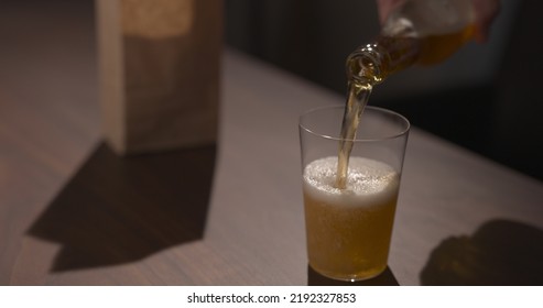 Man Pour Amber Color Fizzy Drink In Tumbler Glass With Bag Of Potato Chips On Background, Wide Photo