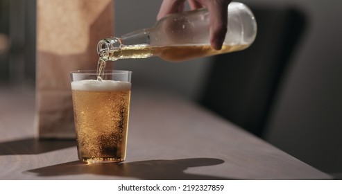 Man Pour Amber Color Fizzy Drink In Tumbler Glass With Bag Of Potato Chips On Background, Wide Photo