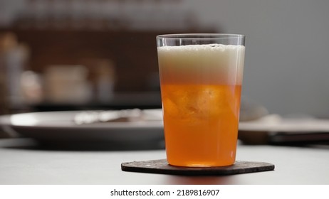 Man Pour Aperitivo In Orange Soda With Ice In Tumbler Glass To Make Spritz Drink On Concrete Countertop, Wide Photo