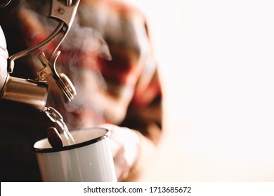 Man Pouring Boiling Water From Kettle In Mug Preparing Coffee Or Tea At Home