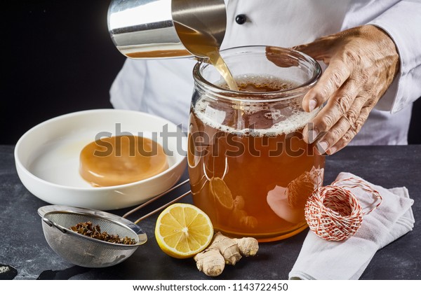 手作りの昆布茶を作りながら 殺菌済みのガラス瓶に甘い黒茶を注ぐ人 の写真素材 今すぐ編集