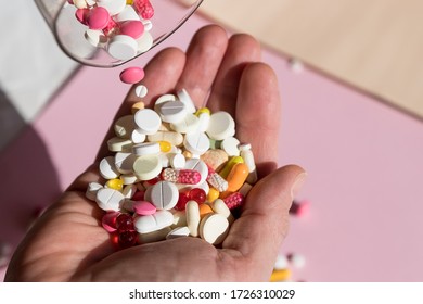 man Pouring capsules from a pill bottle ,holding pills on hand.Overdose of medication. A lot of pills spilled on table. Attempt of suicide.Economic crisis and medicine problems. Virus pandemic.
