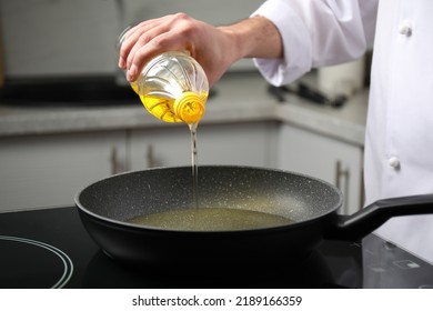 Man Pouring Cooking Oil From Bottle Into Frying Pan, Closeup