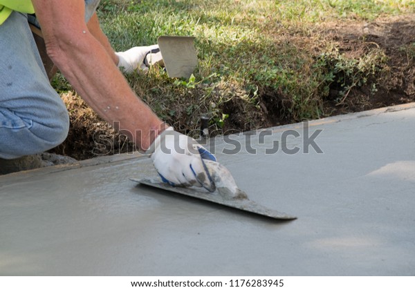 Man Pouring and\
Finishing a Concrete\
Driveway