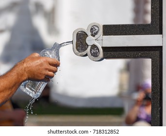 A man pouring the holy water in a bottle from the Holy spring at the Sergiyev Posad monastery. Moscow region, Russia.